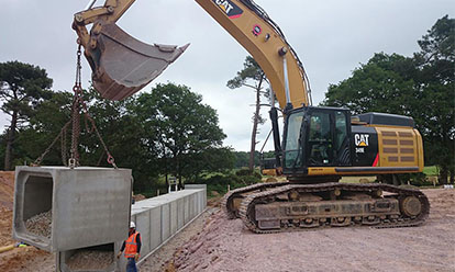 grue soulevant un pont cadre en béton