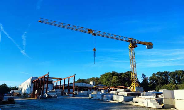 Grue jaune au dessus d'un entrepôt par beau temps